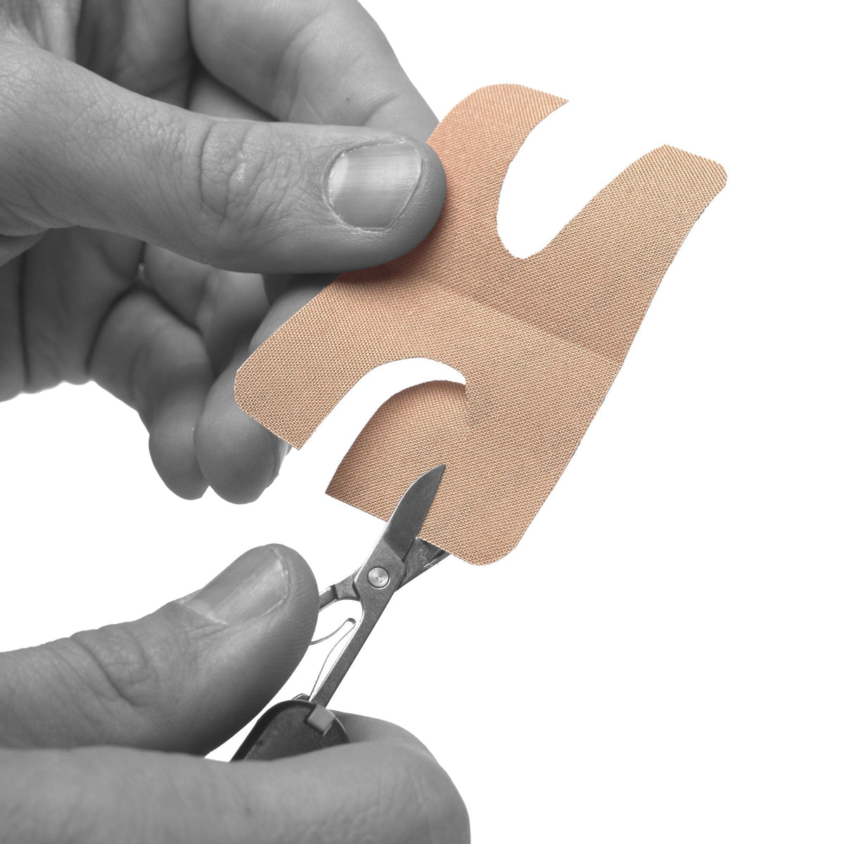 Trimming a Skinshield blister patch to shape with small scissors