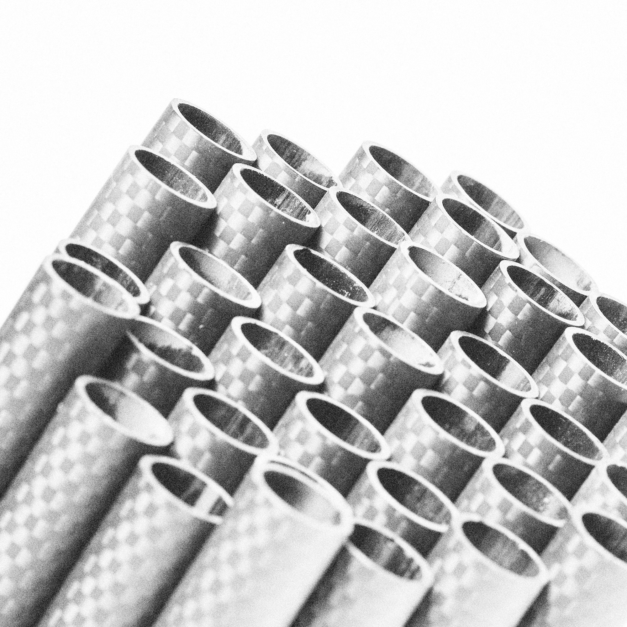 Carbon fiber tubes arranged side by side, showing the woven composite pattern