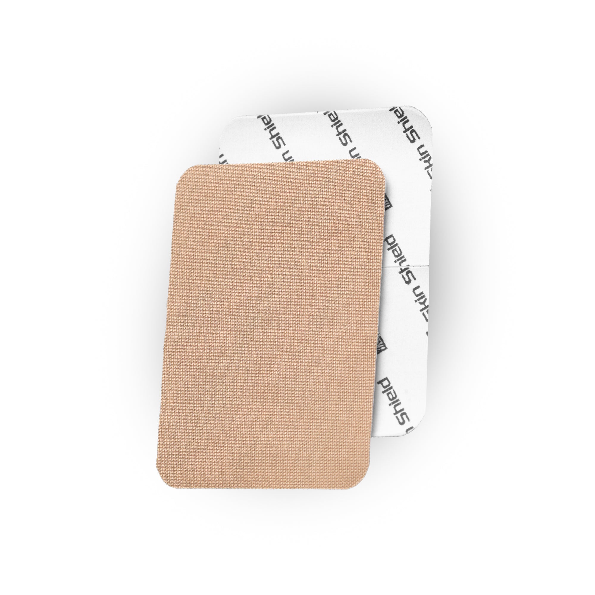A rectangular beige fabric patch with rounded corners, shown in front of a white backing sheet printed with the brand name 'skin shield'.